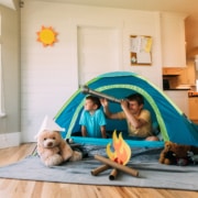 Ferien zuhause - zwei Kinder zelten im Wohnzimmer. Symbolbild: Getty Images / RichVintage / Getty Images E+