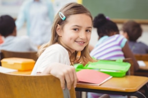 Ein Mädchen sitzt schüchtern und allein in der Schule