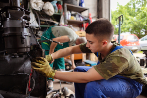Ein Teenager schraubt an einem Motor.