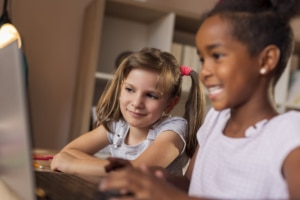 Zwei kleine Kinder spielen an einem Laptop