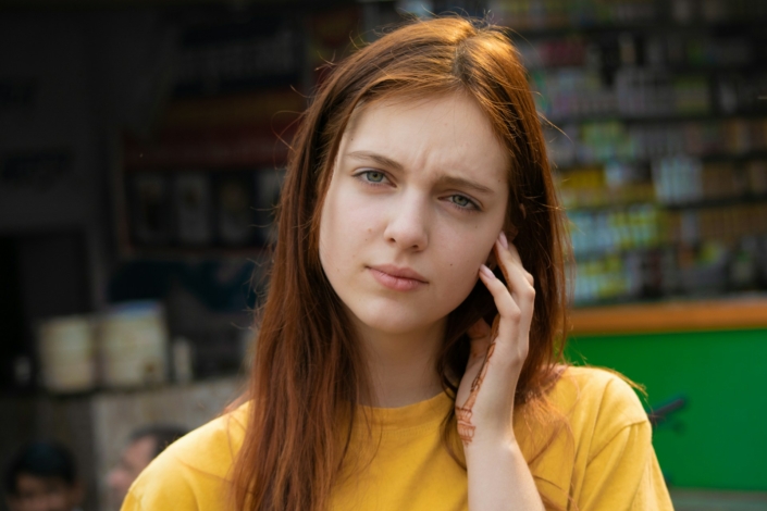 Eine junge Frau schaut fragend in die Kamera.