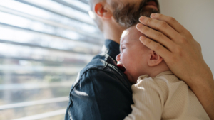 Ein Papa beruhigt sein schreiendes Baby.