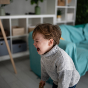 Kind mit Wutausbruch Wütendes und weinendes Kind läuft durch das Zimmer.